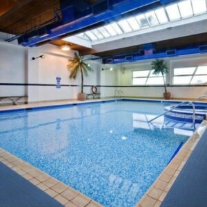 An indoor swimming pool featuring a Wet Step Floor Mat in a large building.