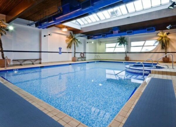 An indoor swimming pool featuring a Wet Step Floor Mat in a large building.