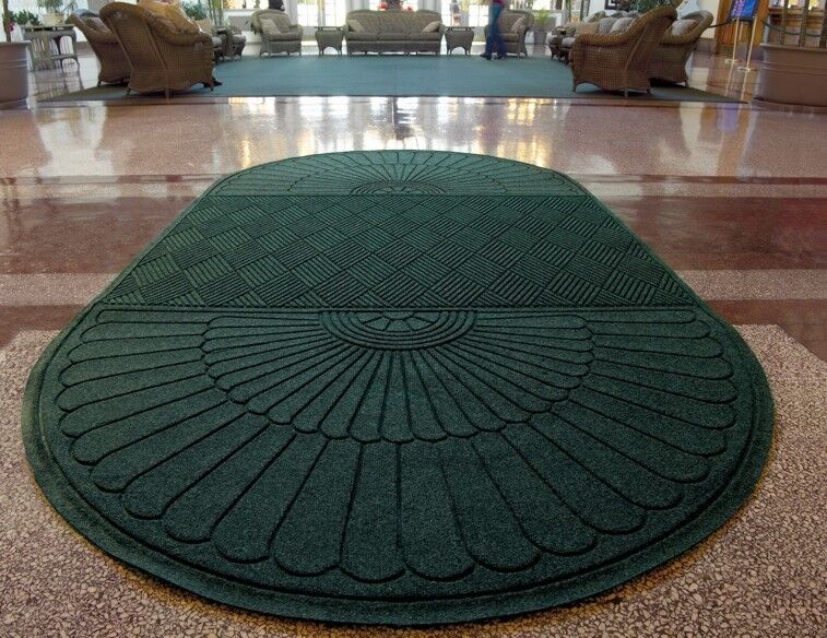 A green carpet mat in a lobby, one of five mats used to maintain and enhance hotel buildings.