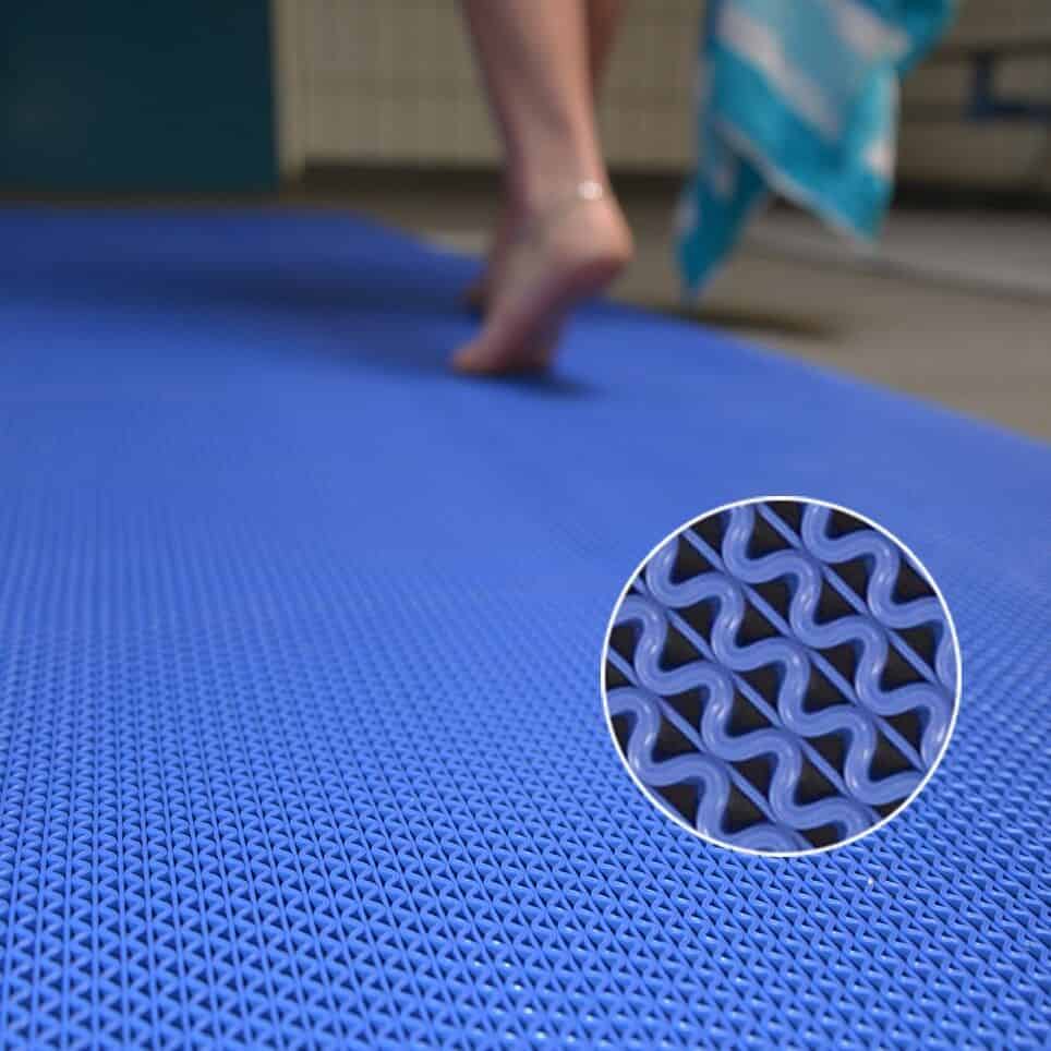 A person is standing on a mat in a swimming pool.